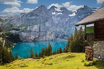 Alpine cabin overlooking turquoise lake and mountains