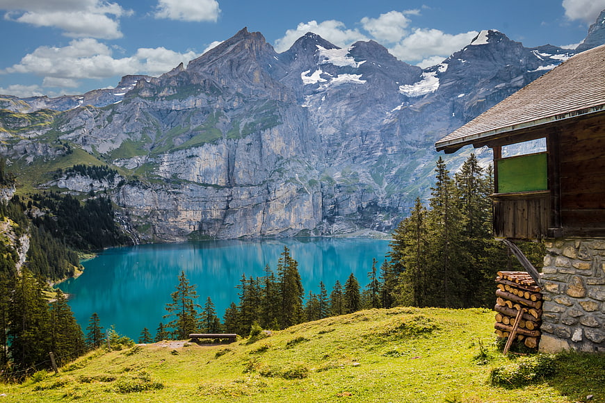 Alpine cabin overlooking turquoise lake and mountains