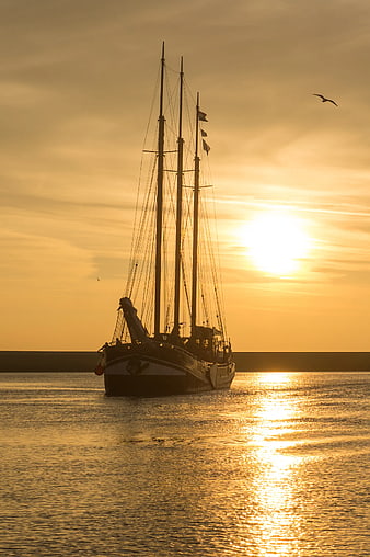 Silhouette of Three-Masted Schooner at Golden Sunset