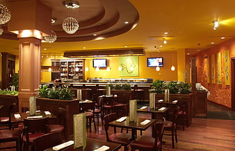 Warmly lit Japanese restaurant interior with wooden tables and bar