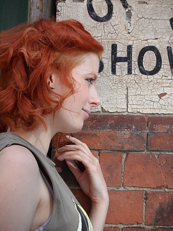 Profile of Redhead Woman Against Weathered Brick Wall