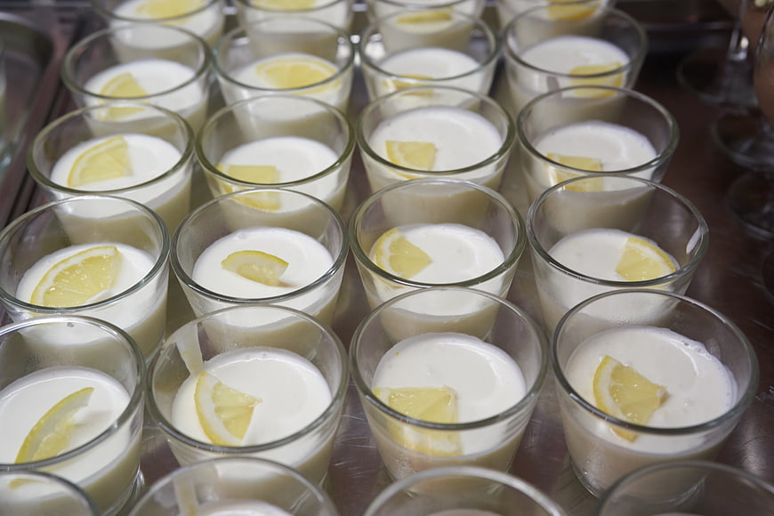 Rows of creamy lemon desserts in glass cups