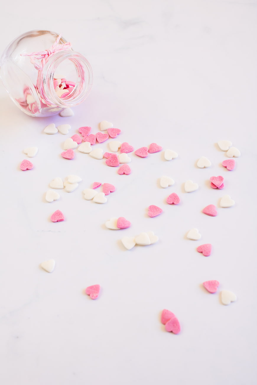 Pink and White Heart Candies Spilled from Glass Jar