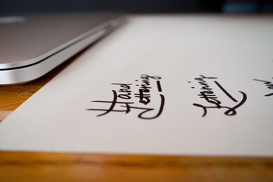 Hand Lettering Design on Paper with Laptop