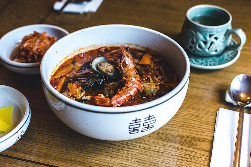 Korean spicy seafood soup with prawns in white bowl