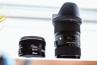 Two Camera Lenses on Wooden Surface with Blurred Background