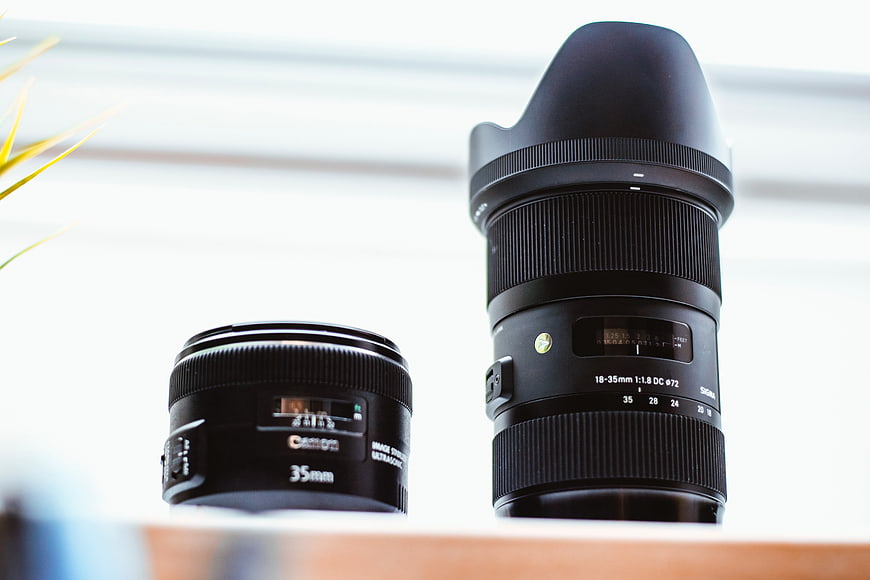 Two Camera Lenses on Wooden Surface with Blurred Background