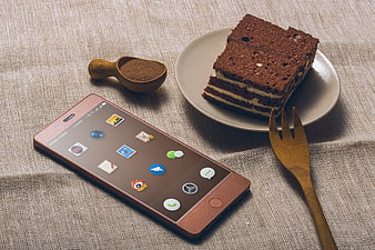 Rose Gold Smartphone Next to Chocolate Cake Slice on Linen