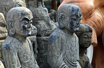 Close-up of weathered stone Buddhist monk statues