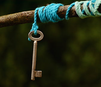 Vintage Key Hanging from Blue Yarn on Rusty Branch