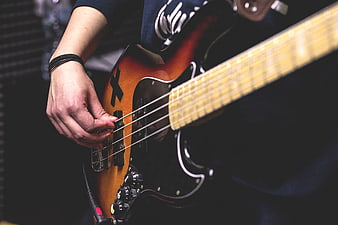 Close-up of musician playing electric bass guitar
