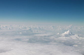 Aerial view of endless white clouds under a clear blue sky