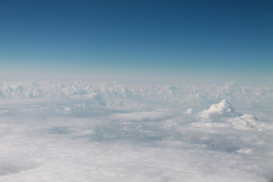 Aerial view of endless white clouds under a clear blue sky