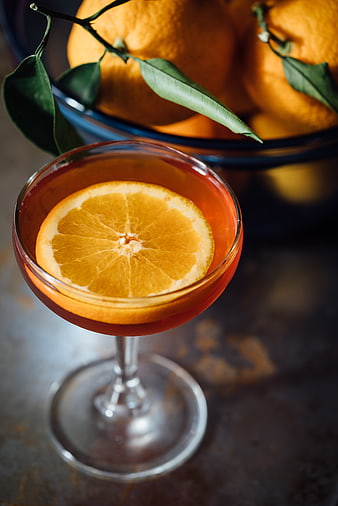 Orange cocktail in coupe glass with citrus garnish