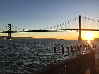 Sunrise over San Francisco Bay Bridge with water foreground