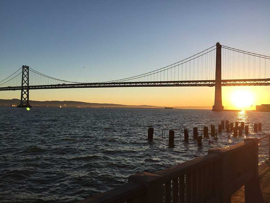 Sunrise over San Francisco Bay Bridge with water foreground