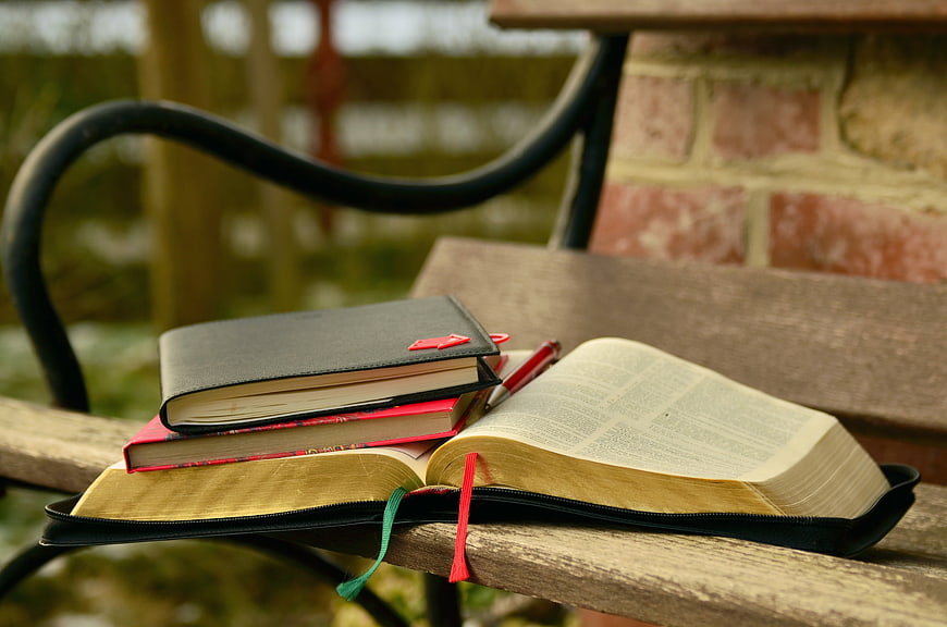 Open Bible and Study Books on Wooden Bench