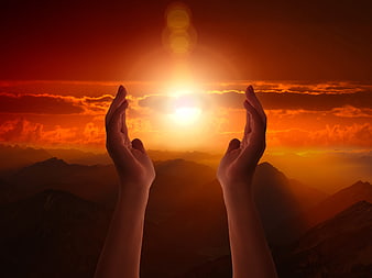 Praying Hands Silhouette Against Dramatic Orange Mountain Sunset