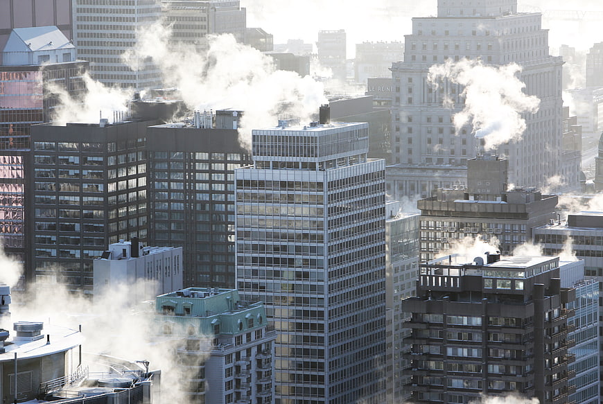 Steam rising from city rooftops in winter urban landscape