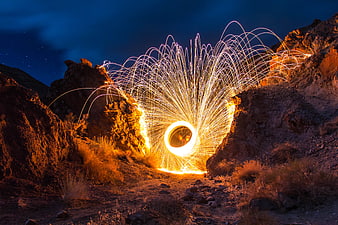 Steel wool photography creating a glowing light trail in a rocky canyon at night