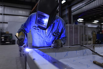 Industrial Welder Working on Metal Frame in Factory