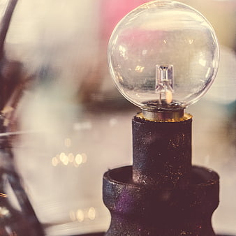 Close-up of vintage Edison bulb on rustic metal stand