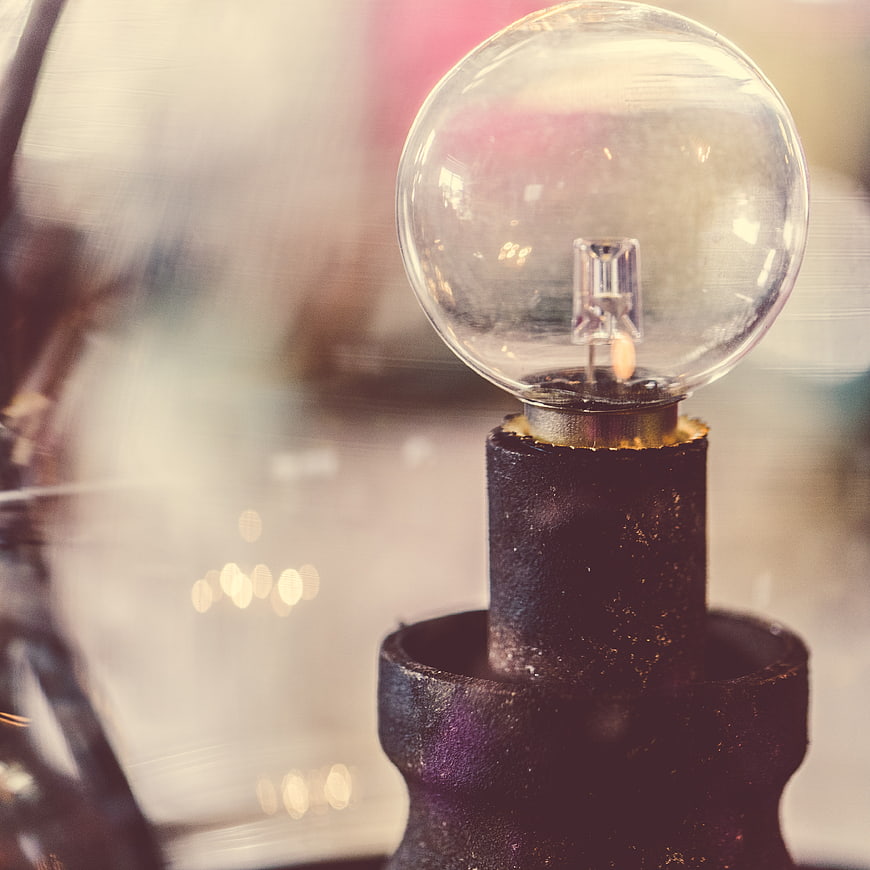 Close-up of vintage Edison bulb on rustic metal stand