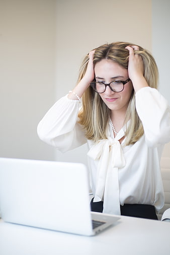 Stressed Businesswoman Holding Head at Laptop