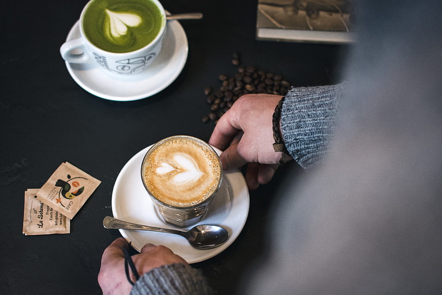 Overhead view of matcha latte and flat white coffee