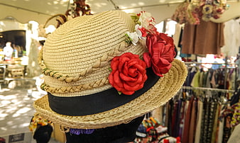 Straw hat with red roses in vintage market stall
