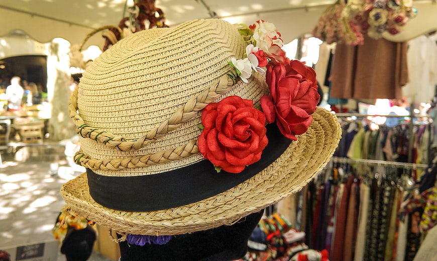 Straw hat with red roses in vintage market stall