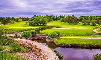 Lush Green Golf Course with Stone Bridge and Water Hazard