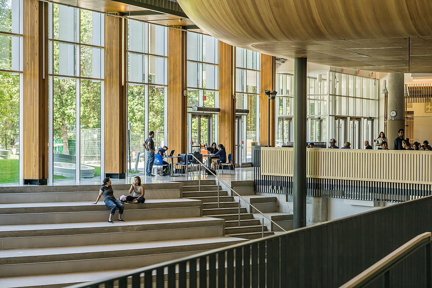 Modern university atrium with students on concrete steps