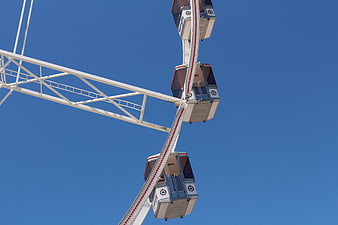 Ferris wheel cabins against clear blue sky