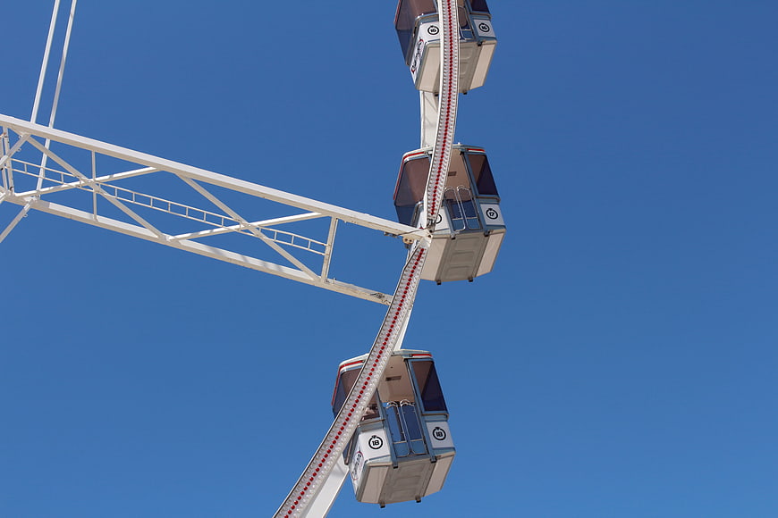 Ferris wheel cabins against clear blue sky