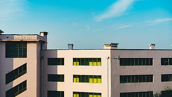 Modern Office Building with Yellow Windows and Blue Sky