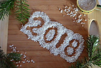 Christmas tree made of rice on wooden board with spruce branches