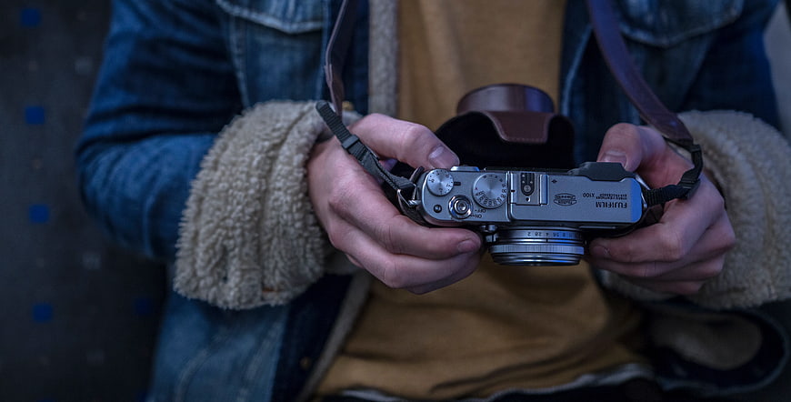Close-up of Hands Holding Vintage Silver Fujifilm Camera