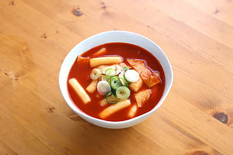 Bowl of spicy Korean tteokbokki with rice cakes and green onions