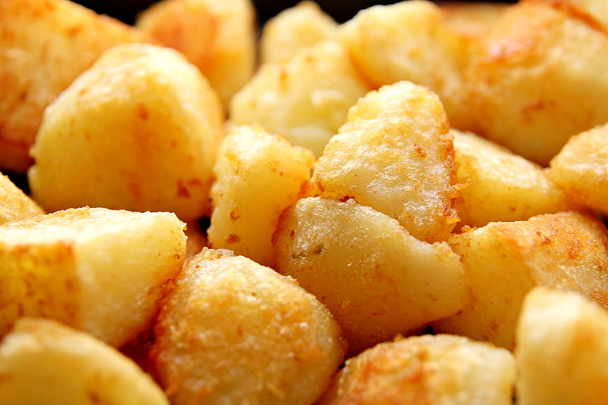 Close-up of golden fried potato chunks with crispy texture