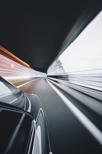 Black car speeding through tunnel with motion blur