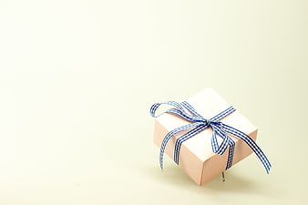 White Gift Box with Blue Ribbon on Cream Background