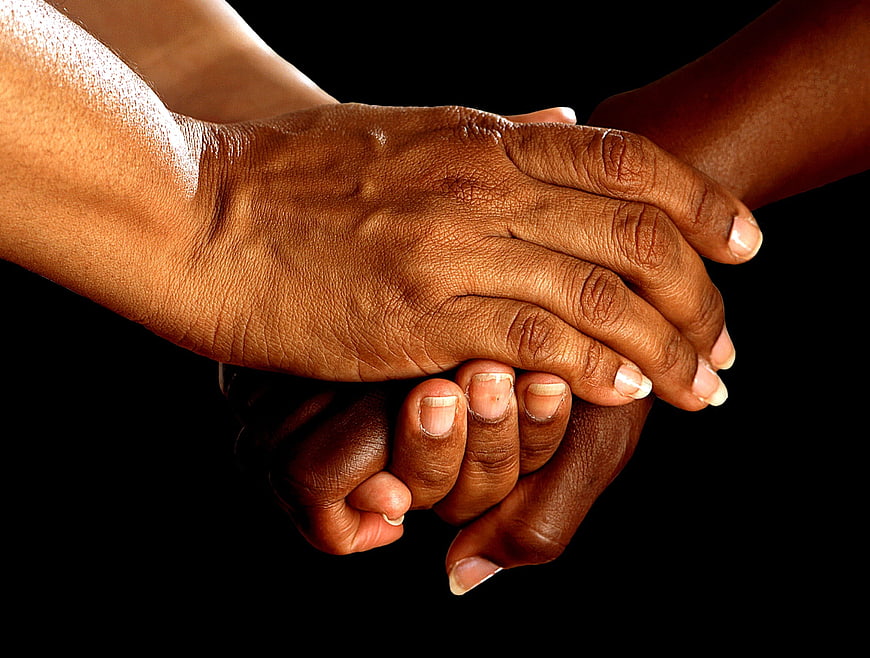 Close-up of two hands holding for support and encouragement