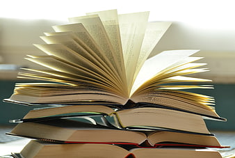Stack of Open Books with Fanned Pages in Warm Light