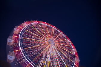 Illuminated Ferris Wheel at Night with Red and White Lights