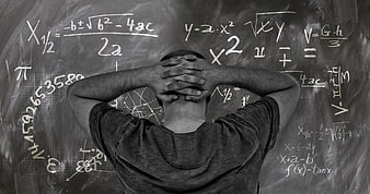 Student stressed with math formulas on chalkboard