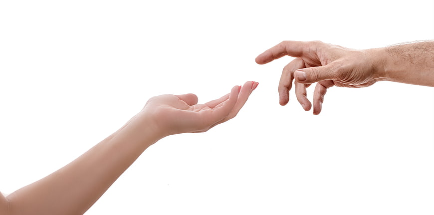 Two Hands Reaching Toward Each Other on White Background
