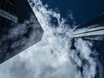 Low angle view of modern skyscrapers against cloudy sky