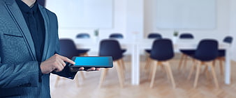 Businessman in suit using tablet in modern office meeting room