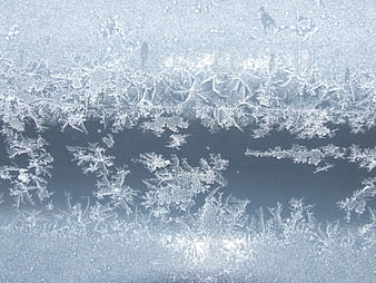 Frost patterns on a window pane with blue background